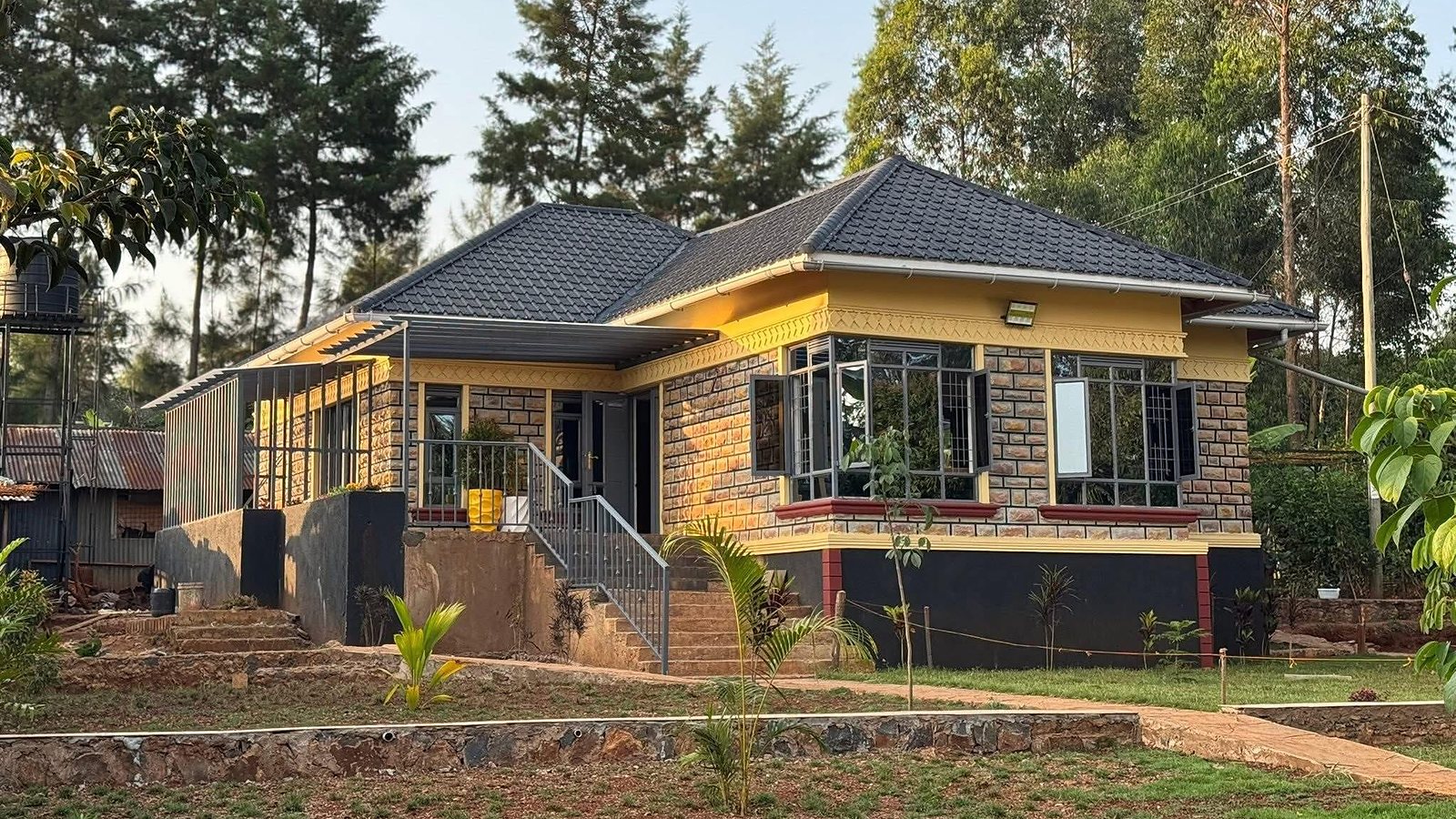 Completed stone bungalow with yellow trim and grey roof
